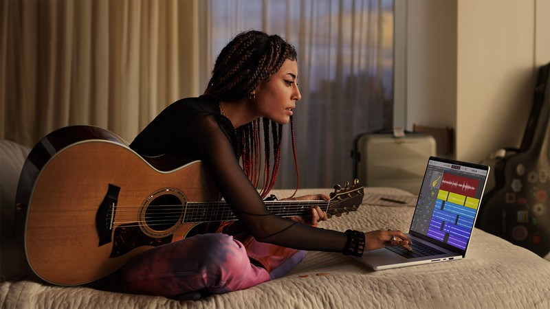 Lady recording music on her MacBook